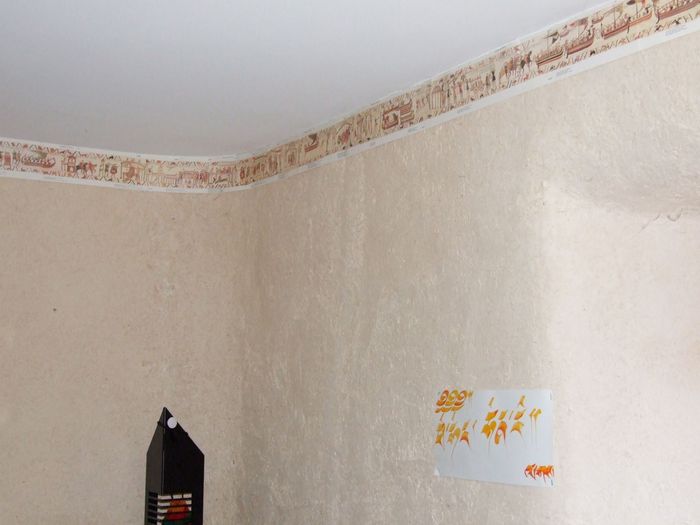 A droite, l'arrondi de la voûte de la fenêtre qu'on devine après ainsi que celui de la gauche de la même fenêtre, et plutôt à gauche, l'arrondi de l'angle du mur.